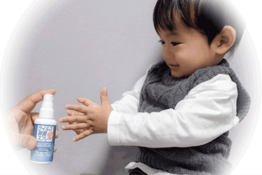 除菌スプレーを使う子供